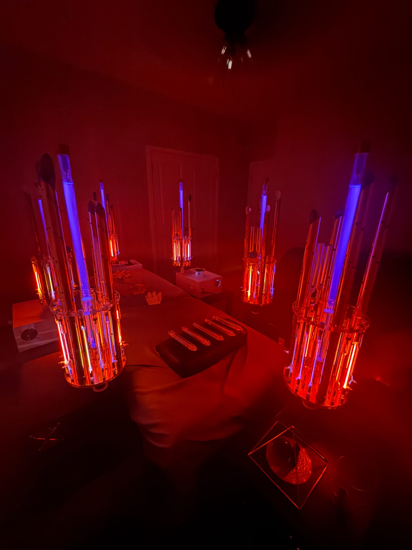 Noble-gas plasma light tubes glowing in a healing session